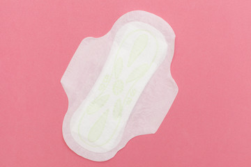 Top view of a feminine sanitary pad on a pink background with space for text. flat lay
