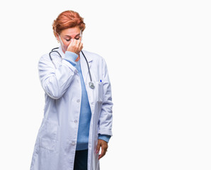 Senior caucasian doctor woman wearing medical uniform over isolated background tired rubbing nose and eyes feeling fatigue and headache. Stress and frustration concept.