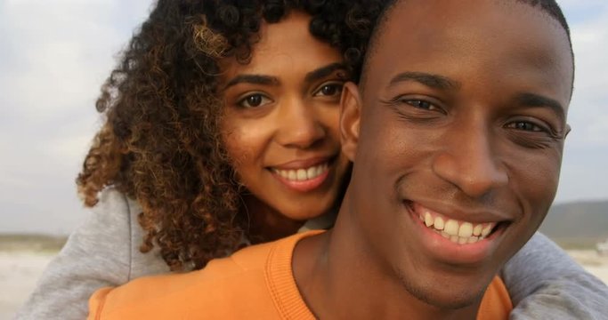 Front view of diverse couple embracing each other on the beach 4k