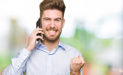 Young handsome man business talking on smartphone screaming proud and celebrating victory and success very excited, cheering emotion