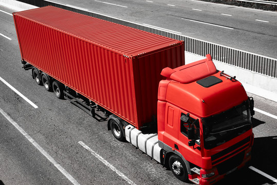 Red truck is going up the road. Cargo transportation concept.