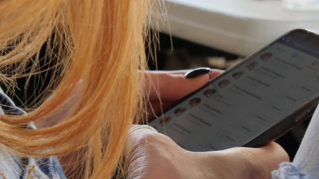Close-up of a smartphone as a woman scrolls through social media on her phone HD