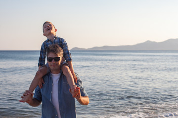 Father holding son on his shoulders at the beach