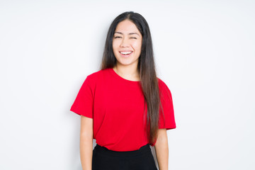 Beautiful brunette woman wearing red t-shirt over isolated background winking looking at the camera...