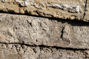 Fototapeta premium Rough limestone wall texture background with stacked stone blocks.