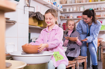 Teacher  instruct children at working with clay