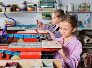 Schoolgirls learning to carve wood during arts and crafts class