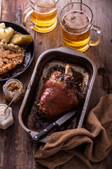 Baked Pork knuckle with beer and cauliflower in roast pan.