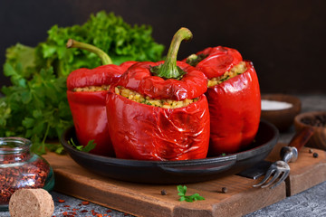 Red pepper stuffed with meat, bulgur and vegetables in a cast-iron pan. Baked stuffed peppers.