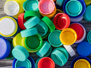 Image of colorful plastic caps on a wooden table