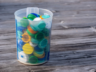 Image of colorful plastic caps on a wooden table