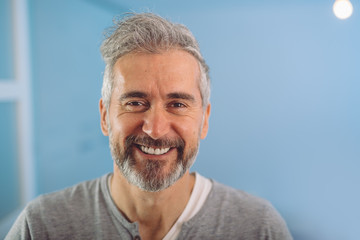 happy middle aged gray haired bearded man smiling