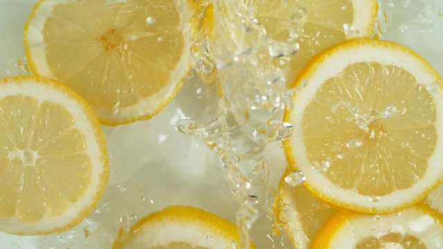 Super slow motion of falling lemon slices into splashing water. Filmed on high speed cinema camera, 1000 fps.