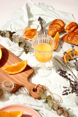 Croissants and oranges on a blue tablecloth