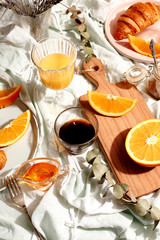 Croissants and oranges on a blue tablecloth