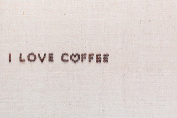 I love coffee sign from coffee beans on linen canvas, arranged middle left.