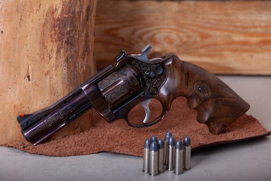 old style revolver handgun photographed on the wooden background