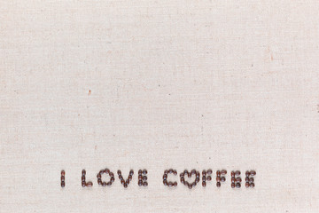 I love coffee sign from coffee beans on linen canvas, arranged bottom center.