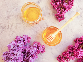 fresh natural honey, blooming lilac on a gray concrete background