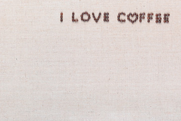 I love coffee sign from coffee beans on linen canvas, arranged top right.