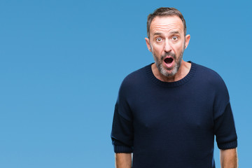 Middle age hoary senior man over isolated background afraid and shocked with surprise expression,...