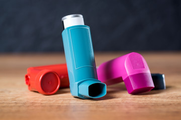 Various asthma inhalers on a wooden table