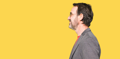 Middle age handsome business man wearing sunglasses looking to side, relax profile pose with...