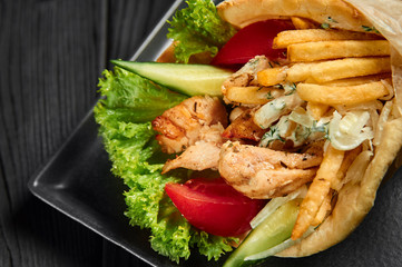 gyro in pita with chicken, vegetables and tzatziki. Greek cuisine dish. healthy fast food. Close up