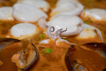 Pella with baby squids in black pan