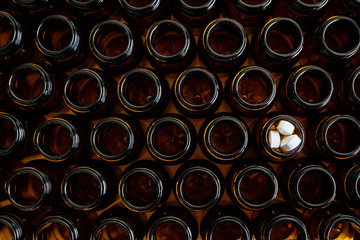 Containers for empty medicines except one full of pills, disease and medicines concept.