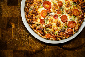 Homemade pizza baked as fast and healthy food on dark wooden table.