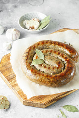 baked homemade sausage with spices and herbs, close up. Spiral grilled sausage.