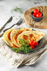 hot homemade pasties on a black dish served with tomatoes