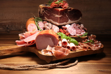 cold meat assortment with delicious salami and  fresh herbs . Variety of meat products including coppa and sausages