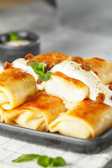 Russian thin pancakes with cottage cheese and raisins. Healthy traditional breakfast