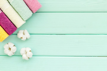Bath accessories made of cotton set with towels on mint green wooden background top view mockup