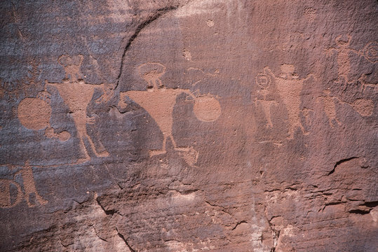 Petroglyphs are ancient mysterious rock drawings and symbols on red sandstone cliffs and canyons in Moab, Utah, USA