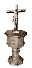 Antique wooden baptismal font and crucifix in sepia tones. Concept that Christ earned forgiveness...