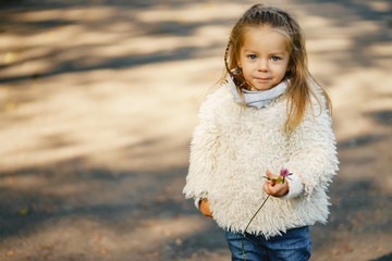 beautifyl energetic toddler girl playing in the park on a sunny day