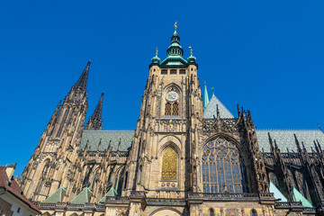 Fototapeta na wymiar Low angle sunny view from courtyard in front of Great South Tower of the Saint Vitus Cathedral and bell tower in Prague, Czech Republic.