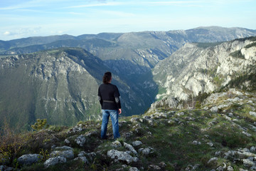 Young man stands in the edge of Tara Canyon and Tara River - Durmitor National Park. Near Zabljak, Montenegro.