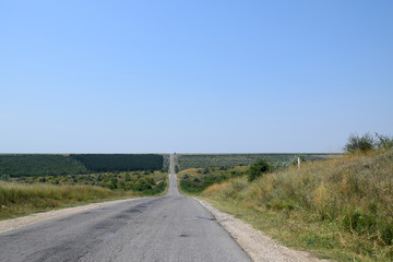 Fototapeta na wymiar Road through hills and valleys. Rural road in Republic of Moldova.