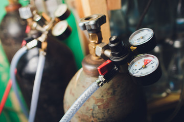 Close up gauges and valve on old nitrogen gas cylinder in laboratory.