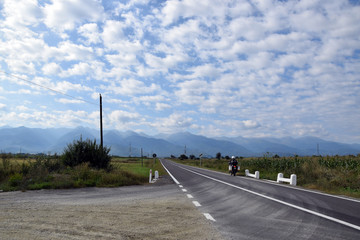 Touristic enduro motorbike in mountain travel. Landscape of Fagaras mountains with Transfagarasan (DN7C) road. Romania.