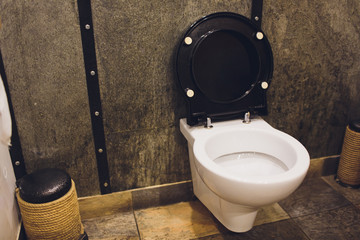 Toilet bowl with bidet shower in toilet.