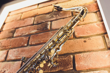 Fototapeta na wymiar Saxophone leaning against a yellow brick wall.
