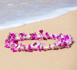 Fototapeta na wymiar Orchid Lei on a Maui beach with soft surf