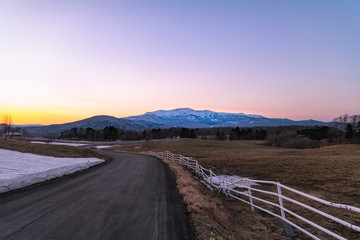 黄昏時の高原の牧場と栗駒山