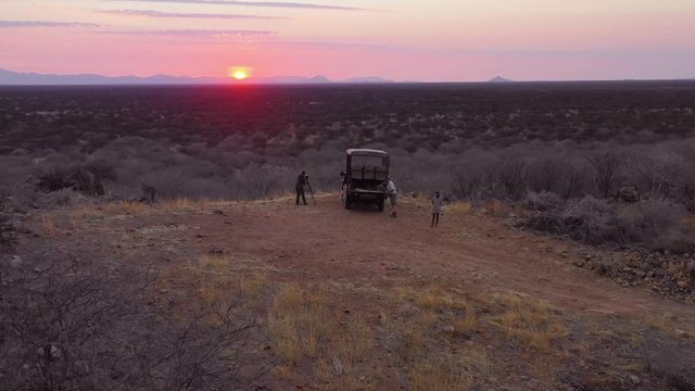 Aerial of tourists enjoying a sunset on a safari jeep at the vast and beautiful Erindi Game Preserve, Namibia.