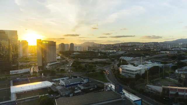 Sunset time lapse during twilight in urban landscape with cars moving on avenue and among buildings in S&atilde;o Paulo City Brasil with the peak of the Jaragu&aacute; in the background